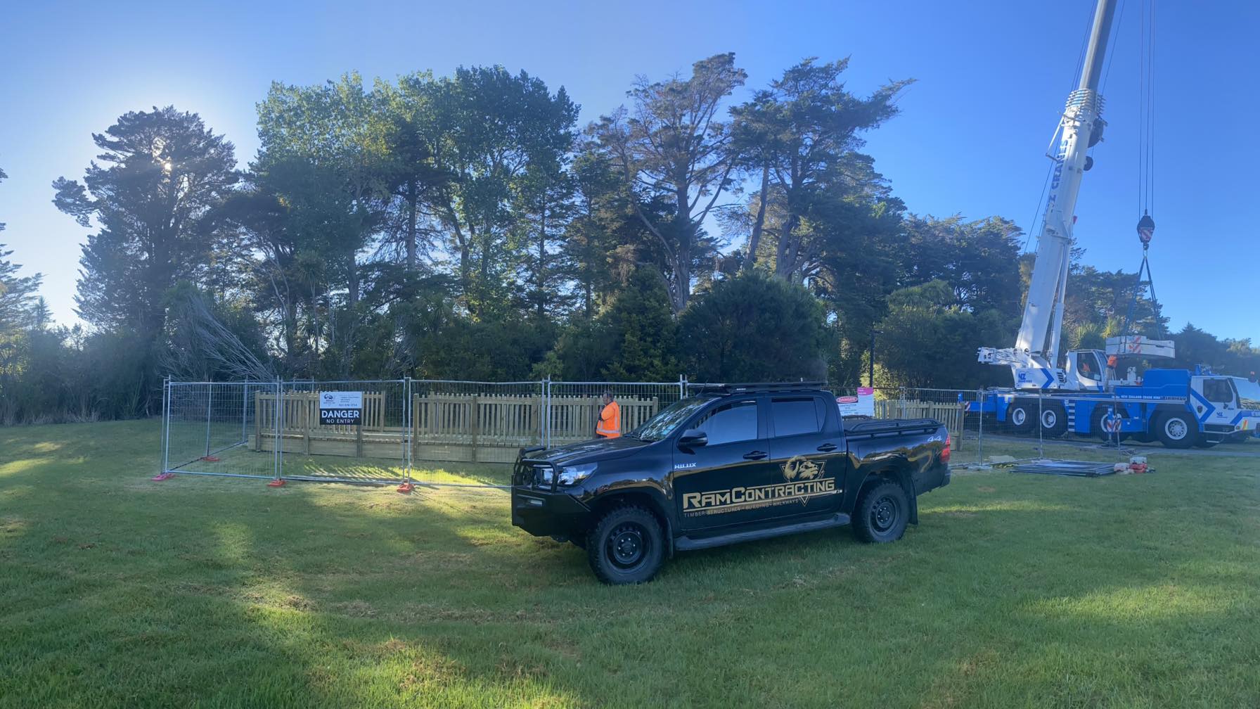 Ram Contracting branded vehicle at job site with crane